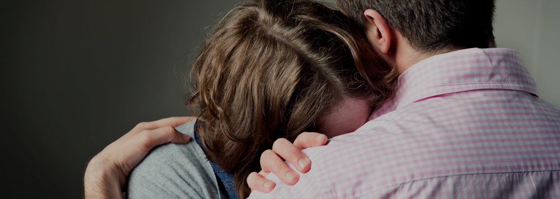 une femme pleure sur l'épaule d'un homme
