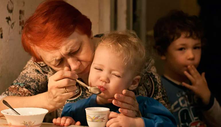 grand-mère suralimente bébé